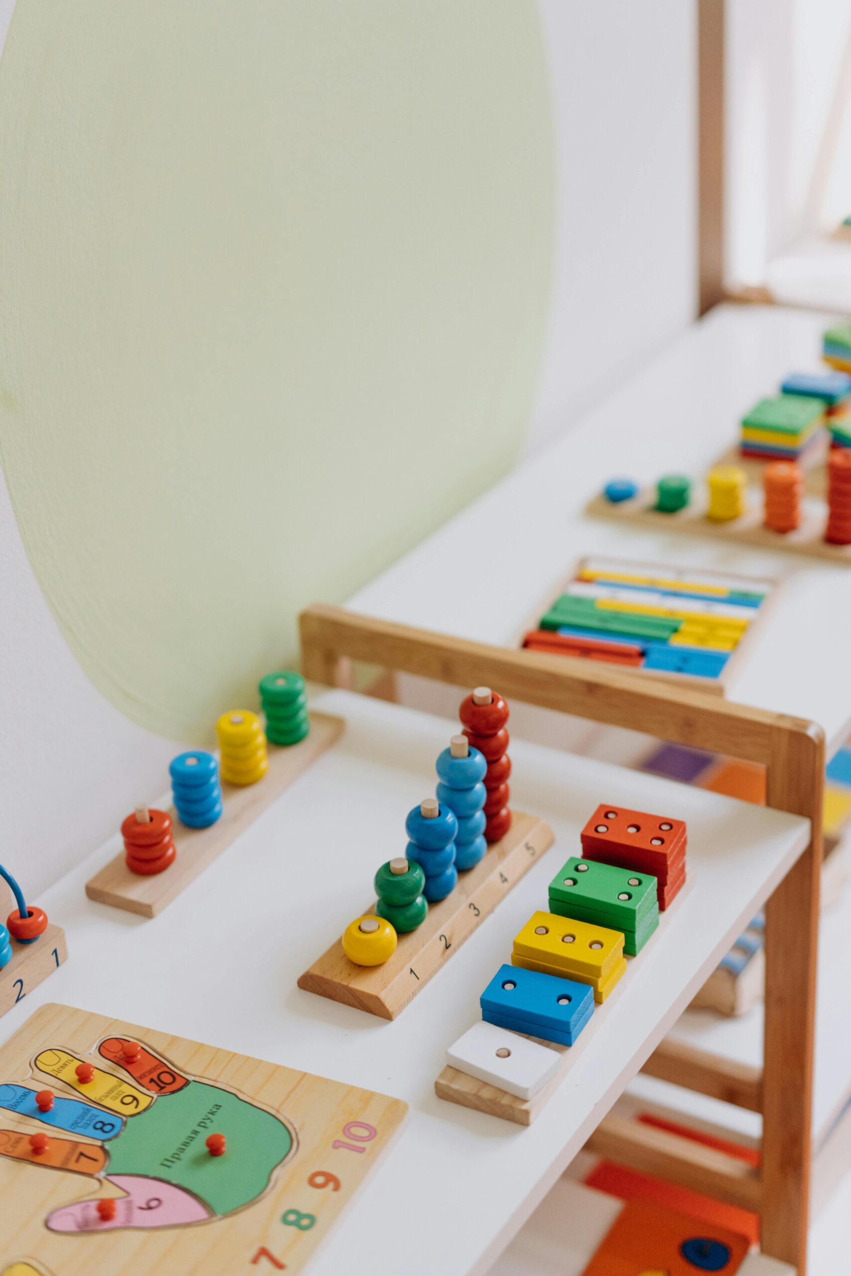 Bright and colorful educational wooden toys displayed on a table in a classroom.